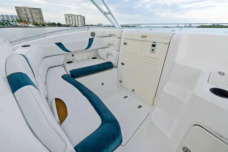 Slide: The Image of 2005 Boston Whaler 320 Outrage Cuddy Cabin interior with seating and storage, docked by waterfront. - 15