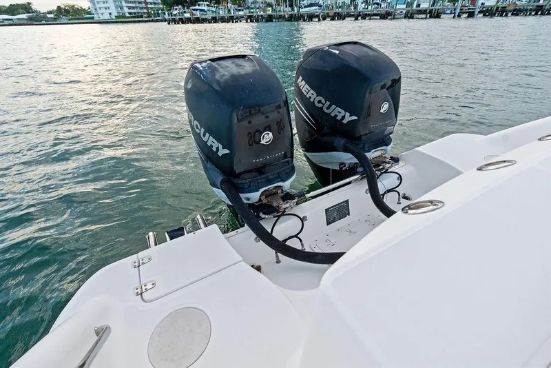 Slide: The Image of 2005 Boston Whaler 320 Outrage Cuddy Cabin with dual Mercury outboard engines on water. - 18