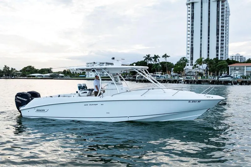 Slide: The Image of 2005 Boston Whaler 320 Outrage Cuddy Cabin on water near urban skyline. - 2