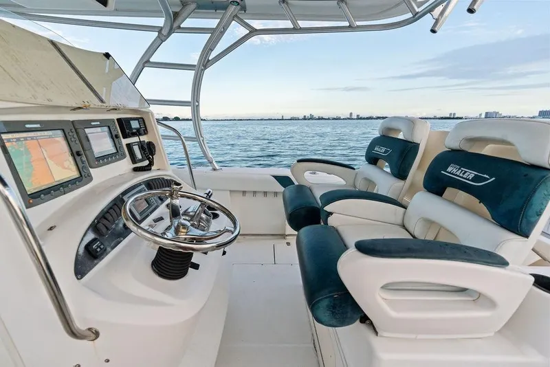 Slide: The Image of 2005 Boston Whaler 320 Outrage Cuddy Cabin helm with dual seats and navigation equipment. - 25