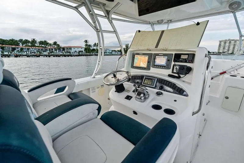 Slide: The Image of 2005 Boston Whaler 320 Outrage Cuddy Cabin helm with navigation equipment and waterfront view. - 26