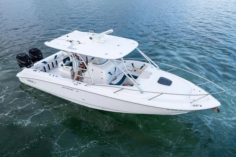 Slide: The Image of 2005 Boston Whaler 320 Outrage Cuddy Cabin on water, showcasing sleek design and twin engines. - 7
