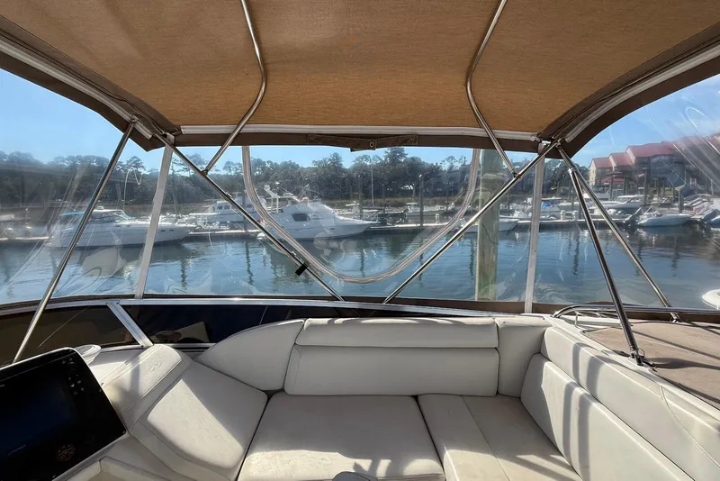 Slide: The Image of Interior view of 2003 Regal Commodore 3880 yacht at marina, featuring comfortable seating. - 14