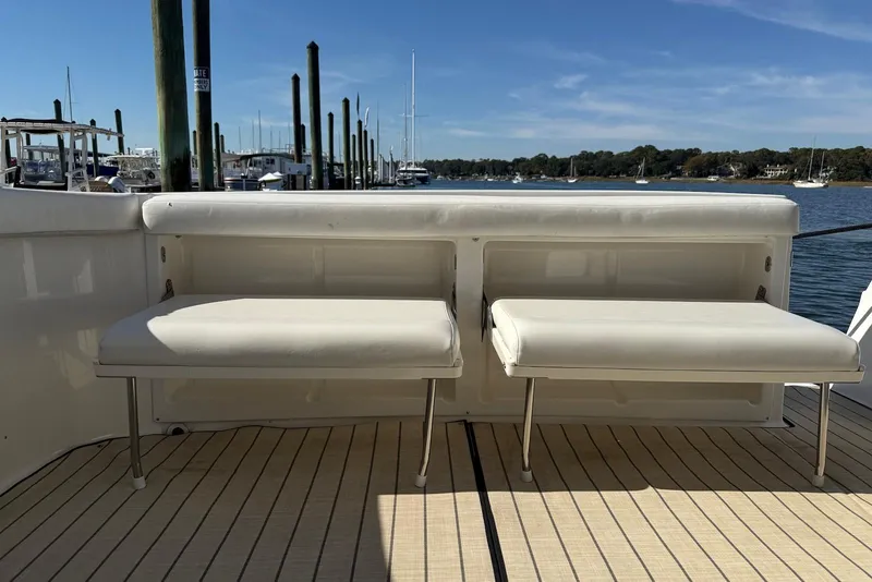 Slide: The Image of 2003 Regal Commodore 3880 yacht with white seating, docked at a marina under clear skies. - 17