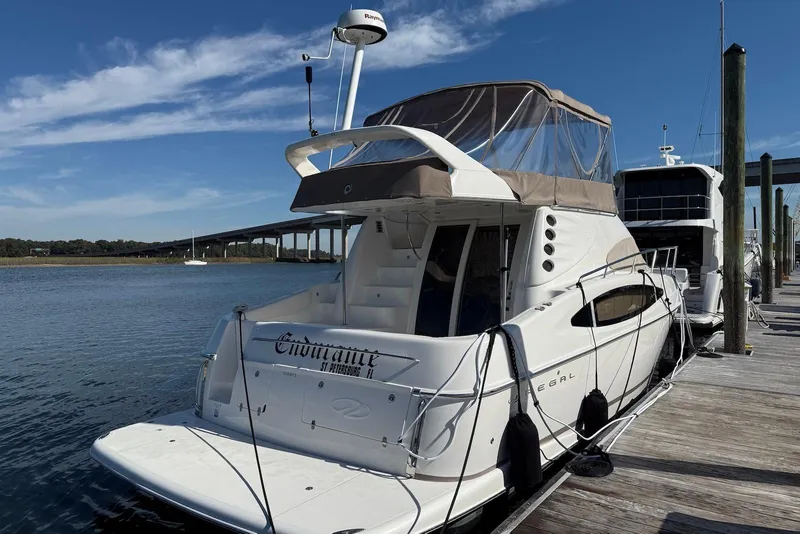 Slide: The Image of 2003 Regal Commodore 3880 yacht docked at marina under clear blue sky. - 18