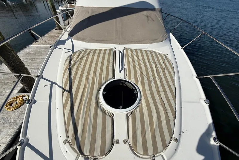 Slide: The Image of 2003 Regal Commodore 3880 yacht deck with striped sun pads and circular hatch. - 19