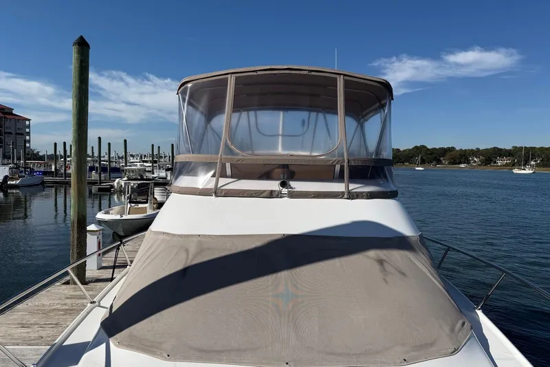 Slide: The Image of 2003 Regal Commodore 3880 yacht docked at a marina under clear blue skies. - 21