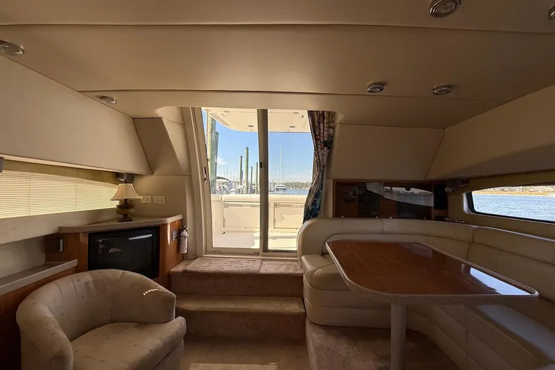 Slide: The Image of Interior of 2003 Regal Commodore 3880 yacht with seating and table, overlooking marina. - 23