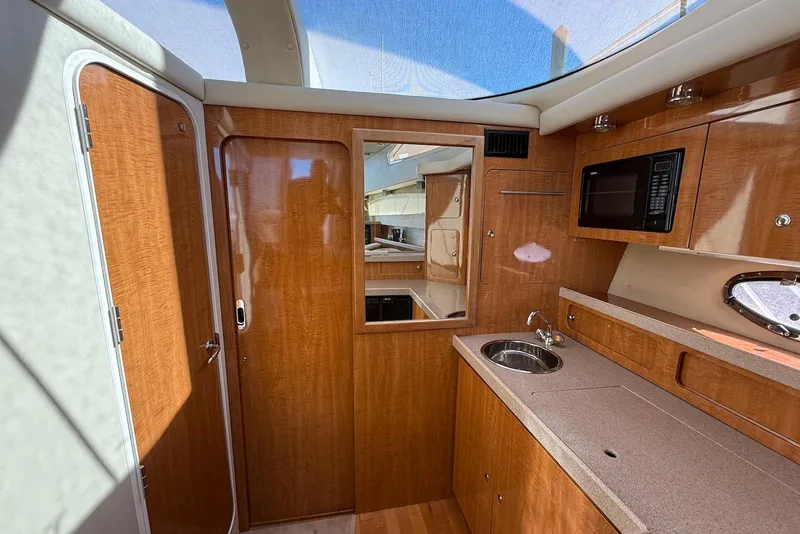 Slide: The Image of 2003 Regal Commodore 3880 yacht interior with wood cabinetry, sink, and microwave. - 27