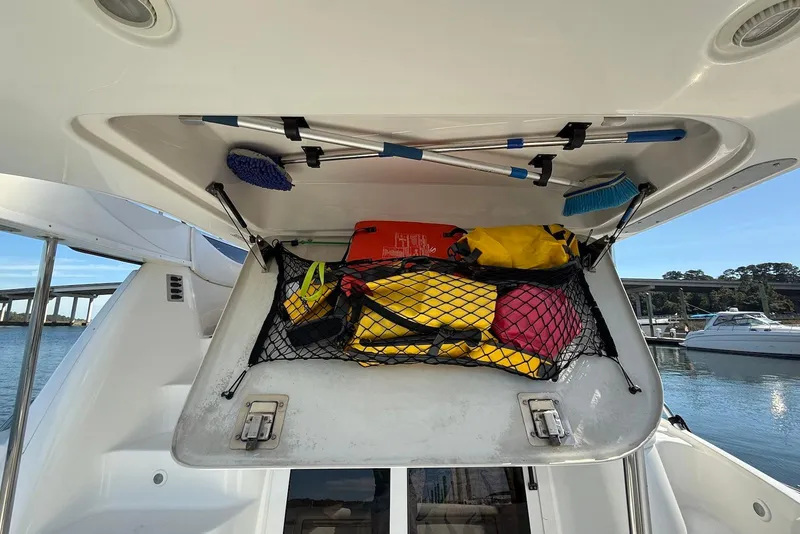 Slide: The Image of Storage compartment on 2003 Regal Commodore 3880 boat with life jackets and cleaning tools. - 30