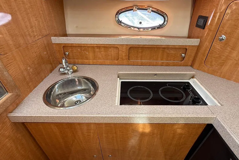 Slide: The Image of 2003 Regal Commodore 3880 yacht kitchen with sink, stove, and wooden cabinetry. - 35