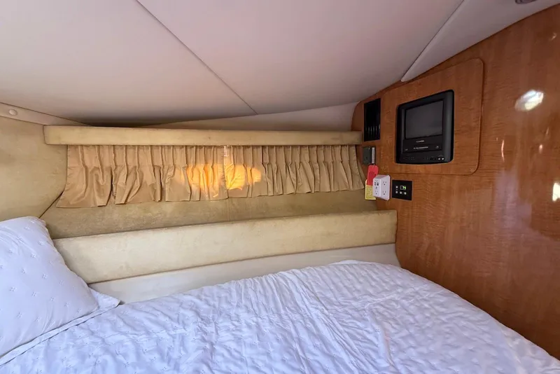 Slide: The Image of 2003 Regal Commodore 3880 cabin interior with bed, TV, and wooden paneling. - 45