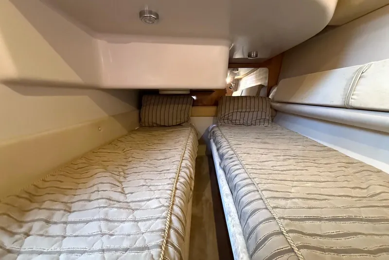 Slide: The Image of 2003 Regal Commodore 3880 cabin with twin beds and striped bedding. - 47