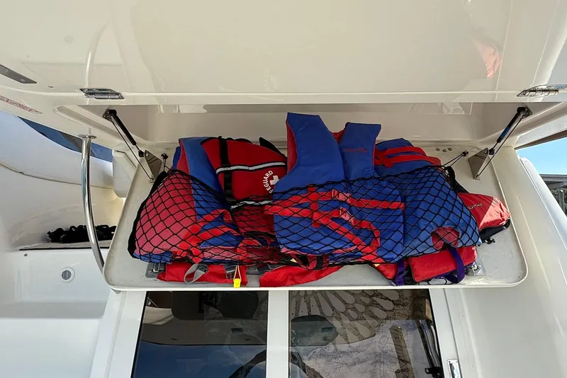 Slide: The Image of Storage compartment with life jackets on a 2003 Regal Commodore 3880 boat. - 48