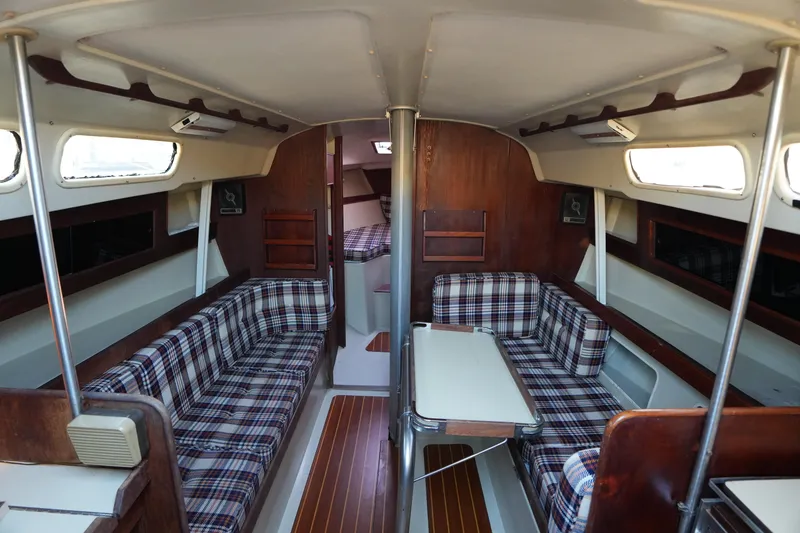 Slide: The Image of Interior of a 1978 C&C 34 sailboat with plaid seating and wooden accents. - 10