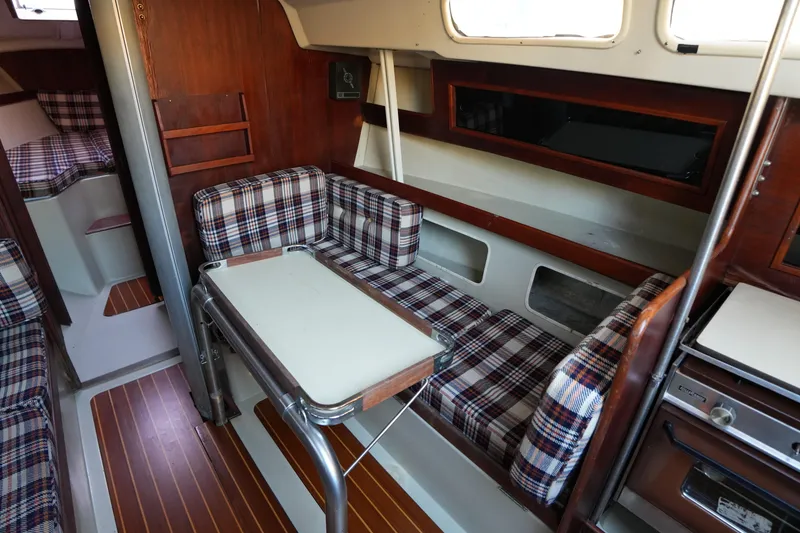 Slide: The Image of Interior of a 1978 C&C 34 sailboat with plaid seating and wooden accents. - 12