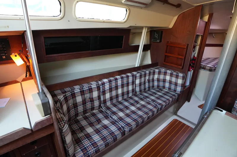 Slide: The Image of Interior of a 1978 C&C 34 sailboat with plaid seating and wooden accents. - 13