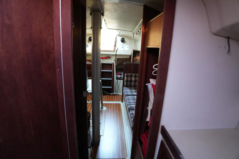 Slide: The Image of Interior of a 1978 C&C 34 sailboat with wood paneling and plaid seating. - 14