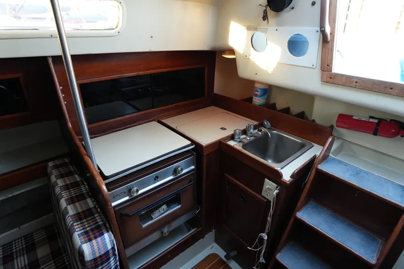 Slide: The Image of 1978 C&C 34 sailboat interior kitchen with stove, sink, and wooden cabinetry. - 15
