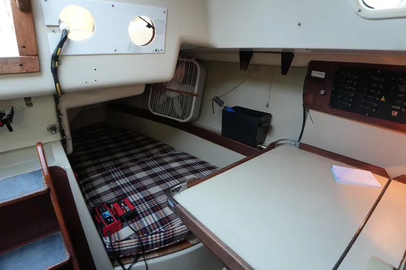 Slide: The Image of 1978 C&C 34 sailboat interior with plaid bedding and navigation panel. - 17