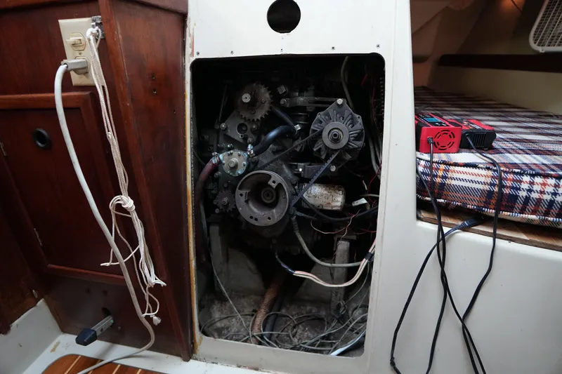 Slide: The Image of Engine compartment of a 1978 C&C 34 sailboat with visible wiring and tools. - 19