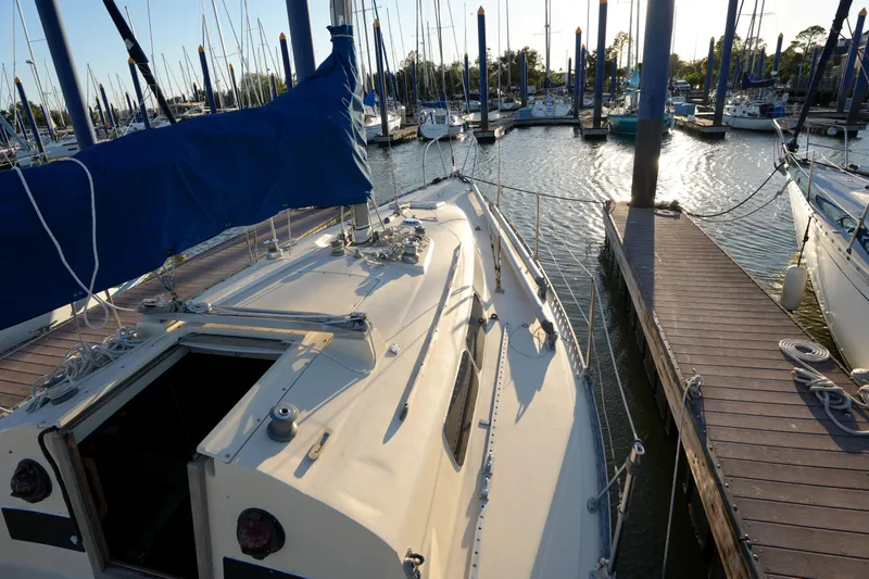 Slide: The Image of 1978 C&C 34 sailboat docked at marina, surrounded by other boats. - 5