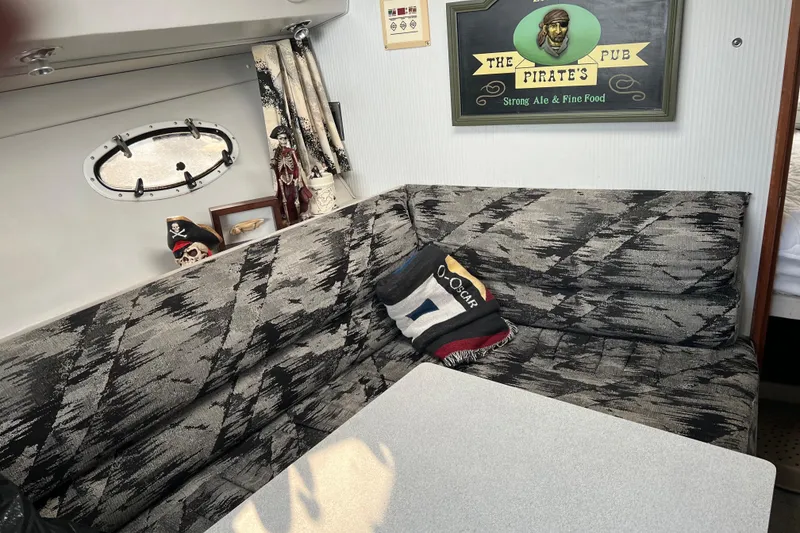 Slide: The Image of Cozy interior of 1990 Trojan 10 Meter Express 330 with pirate-themed decor. - 11