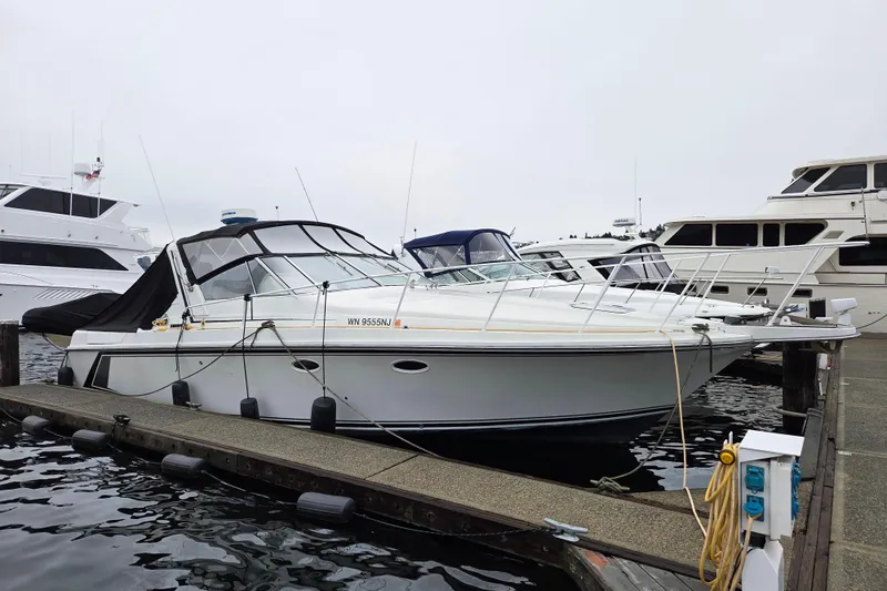 Slide: The Image of 1990 Trojan 10 Meter Express 330 docked at marina, surrounded by other boats. - 2