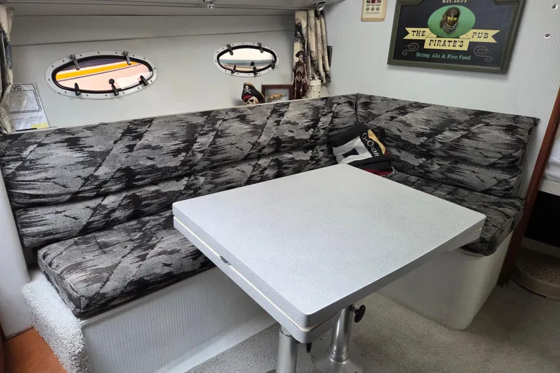 Slide: The Image of Cozy interior of 1990 Trojan 10 Meter Express 330 with patterned seating and table. - 23