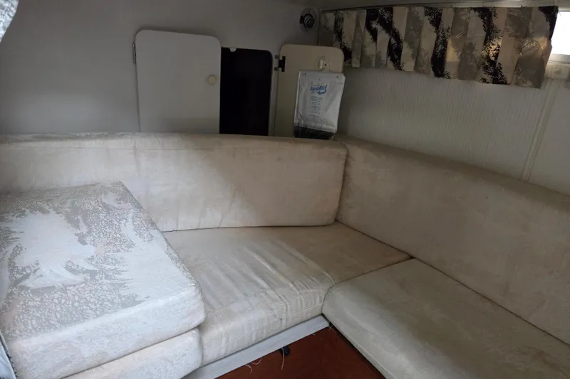 Slide: The Image of Interior of a 1990 Trojan 10 Meter Express 330 with beige seating and patterned curtains. - 26