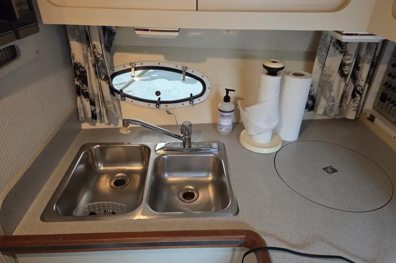Slide: The Image of 1990 Trojan 10 Meter Express 330 kitchen with double sink and porthole window. - 29