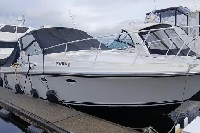 Slide: The Image of 1990 Trojan 10 Meter Express 330 boat docked at marina, featuring sleek white design. - 3