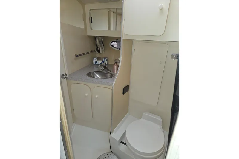Slide: The Image of 1990 Trojan 10 Meter Express 330 boat bathroom with sink, toilet, and storage cabinets. - 39