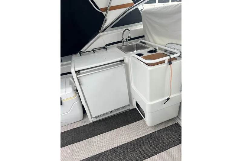 Slide: The Image of 1990 Trojan 10 Meter Express 330 boat galley with sink, fridge, and storage. - 9