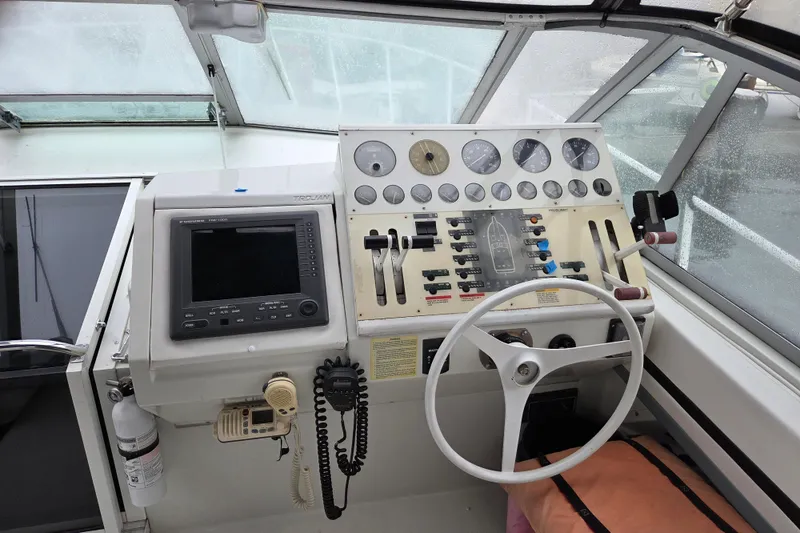 Slide: The Image of Cockpit of 1990 Trojan 10 Meter Express 330 with navigation equipment and steering wheel. - 12