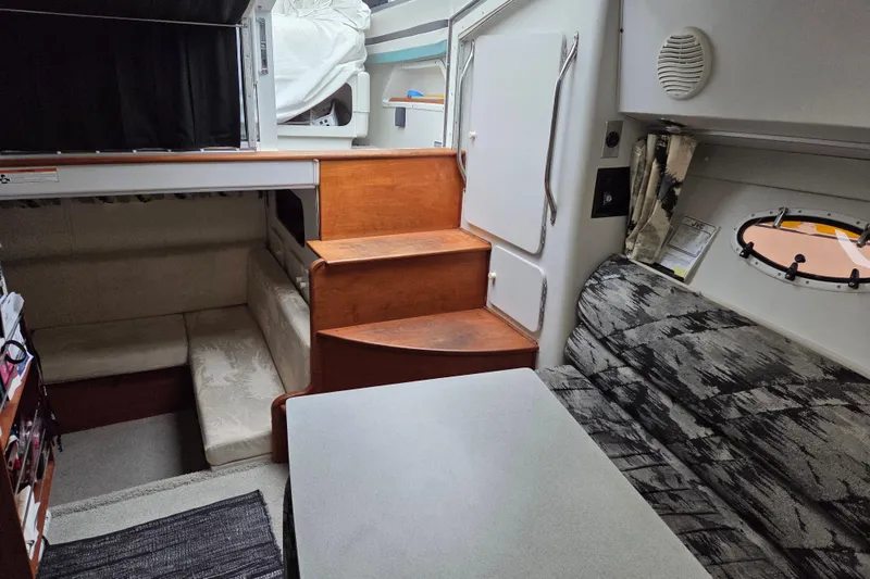 Slide: The Image of Interior of 1990 Trojan 10 Meter Express 330 boat, featuring seating and wooden steps. - 22