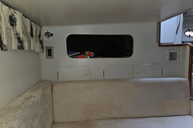 Slide: The Image of 1990 Trojan 10 Meter Express 330 interior with beige seating and patterned curtains. - 27
