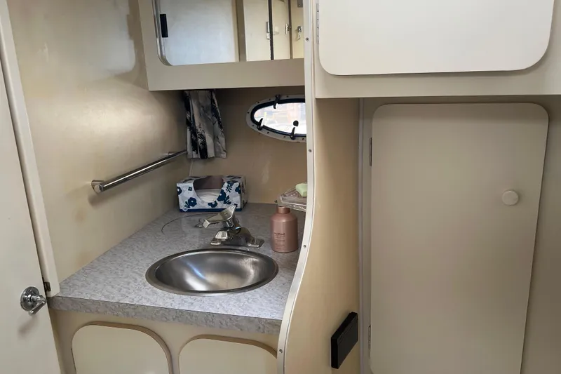 Slide: The Image of 1990 Trojan 10 Meter Express 330 boat bathroom with sink, mirror, and storage. - 38