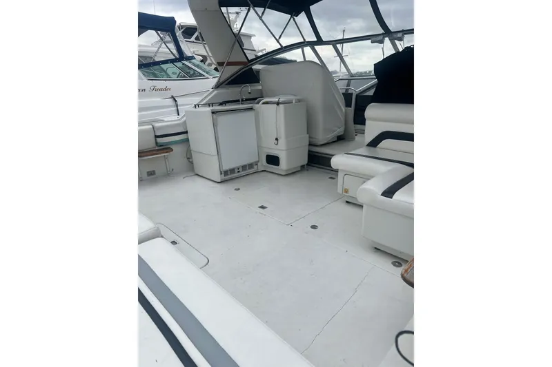 Slide: The Image of 1990 Trojan International 10 Meter Express boat interior with seating and kitchenette. - 46