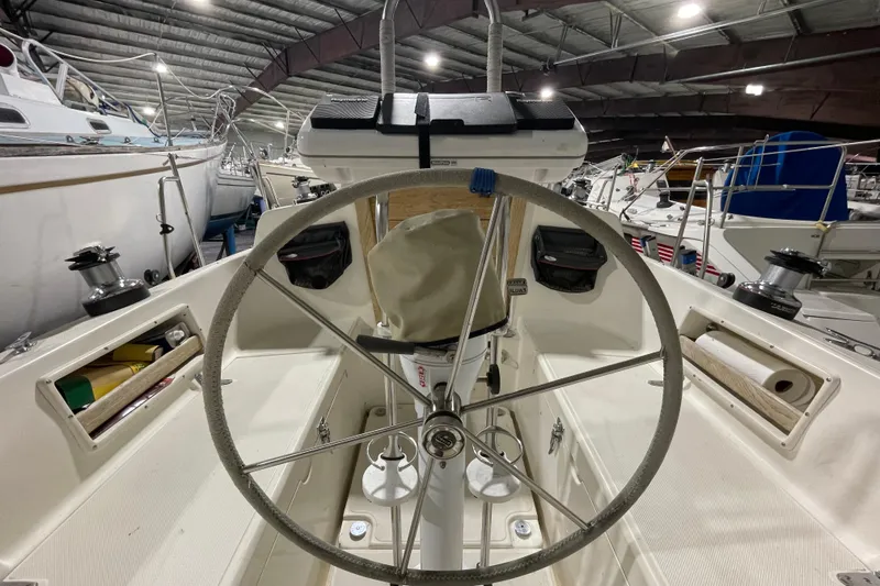 Slide: The Image of Steering wheel of a 1997 Pacific Seacraft 34 sailboat in a covered marina. - 10