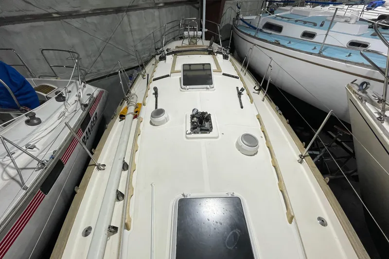 Slide: The Image of 1997 Pacific Seacraft 34 sailboat deck view in storage, surrounded by other boats. - 15