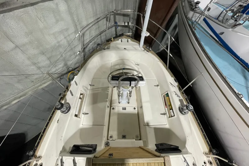 Slide: The Image of 1997 Pacific Seacraft 34 sailboat cockpit, featuring steering wheel and winches, docked indoors. - 16