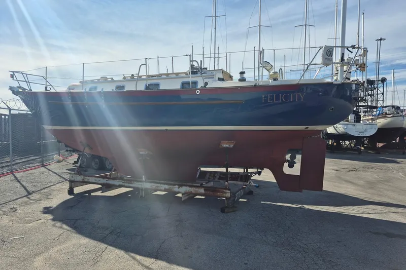 Slide: The Image of 1997 Pacific Seacraft 34 sailboat named "Felicity" on a trailer in a boatyard. - 2