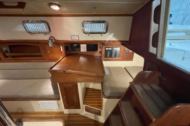 Slide: The Image of Interior of 1997 Pacific Seacraft 34 sailboat with wooden cabinetry and seating area. - 21