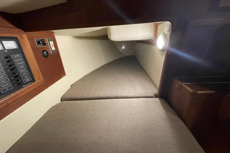 Slide: The Image of Interior cabin of 1997 Pacific Seacraft 34 sailboat with cushioned berth and control panel. - 24