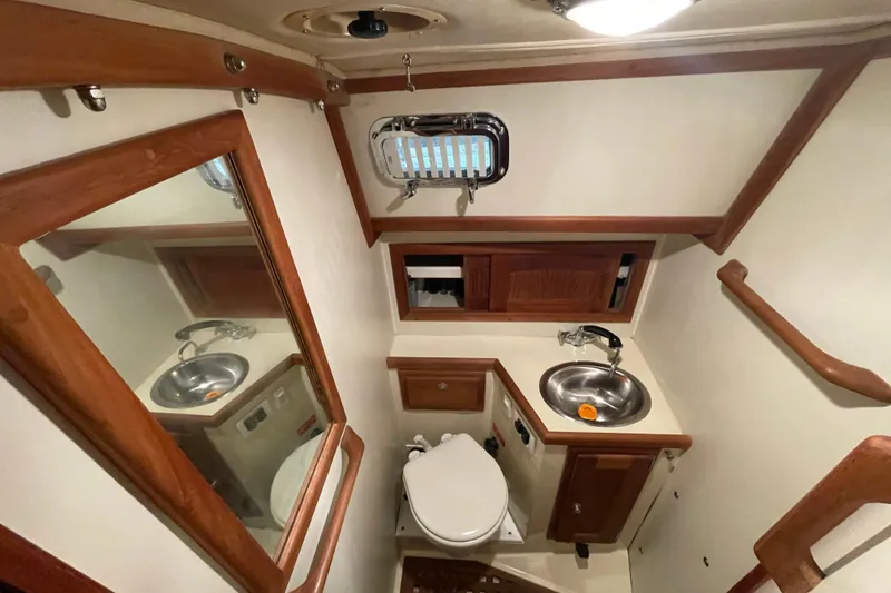 Slide: The Image of Bathroom interior of 1997 Pacific Seacraft 34 yacht with sink, toilet, and wooden accents. - 27