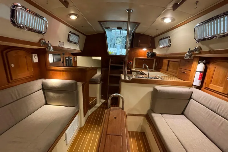 Slide: The Image of Interior of a 1997 Pacific Seacraft 34 sailboat with cozy seating and wooden finishes. - 28