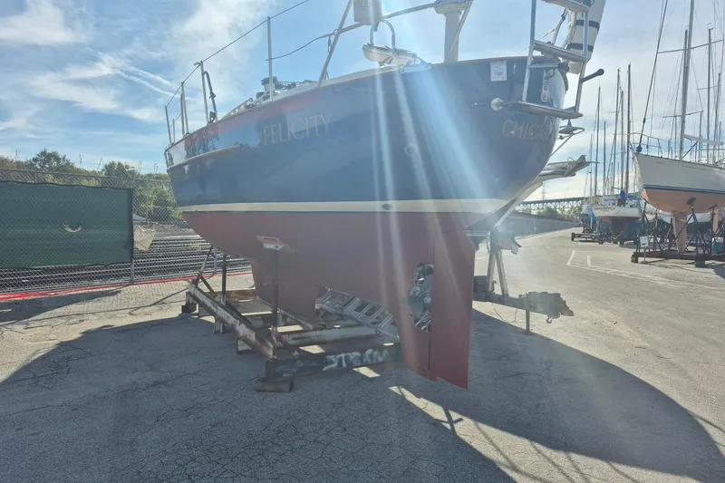 Slide: The Image of 1997 Pacific Seacraft 34 sailboat on dry dock, sunlight streaming, marina background. - 3