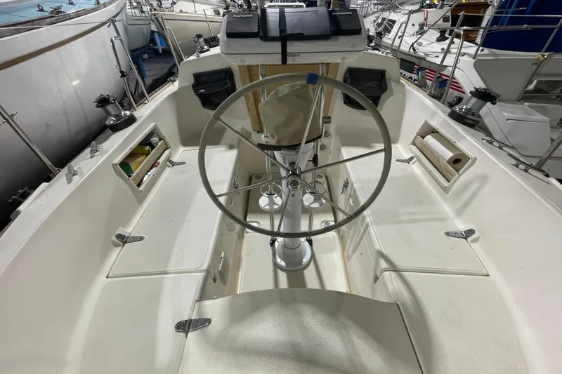 Slide: The Image of Cockpit of 1997 Pacific Seacraft 34 sailboat with steering wheel and storage compartments. - 9