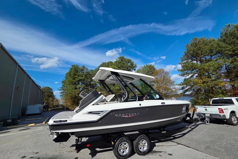 Slide: The Image of Dog on 2026 Monterey Elite 27 SD boat with autumn trees in background. - 8